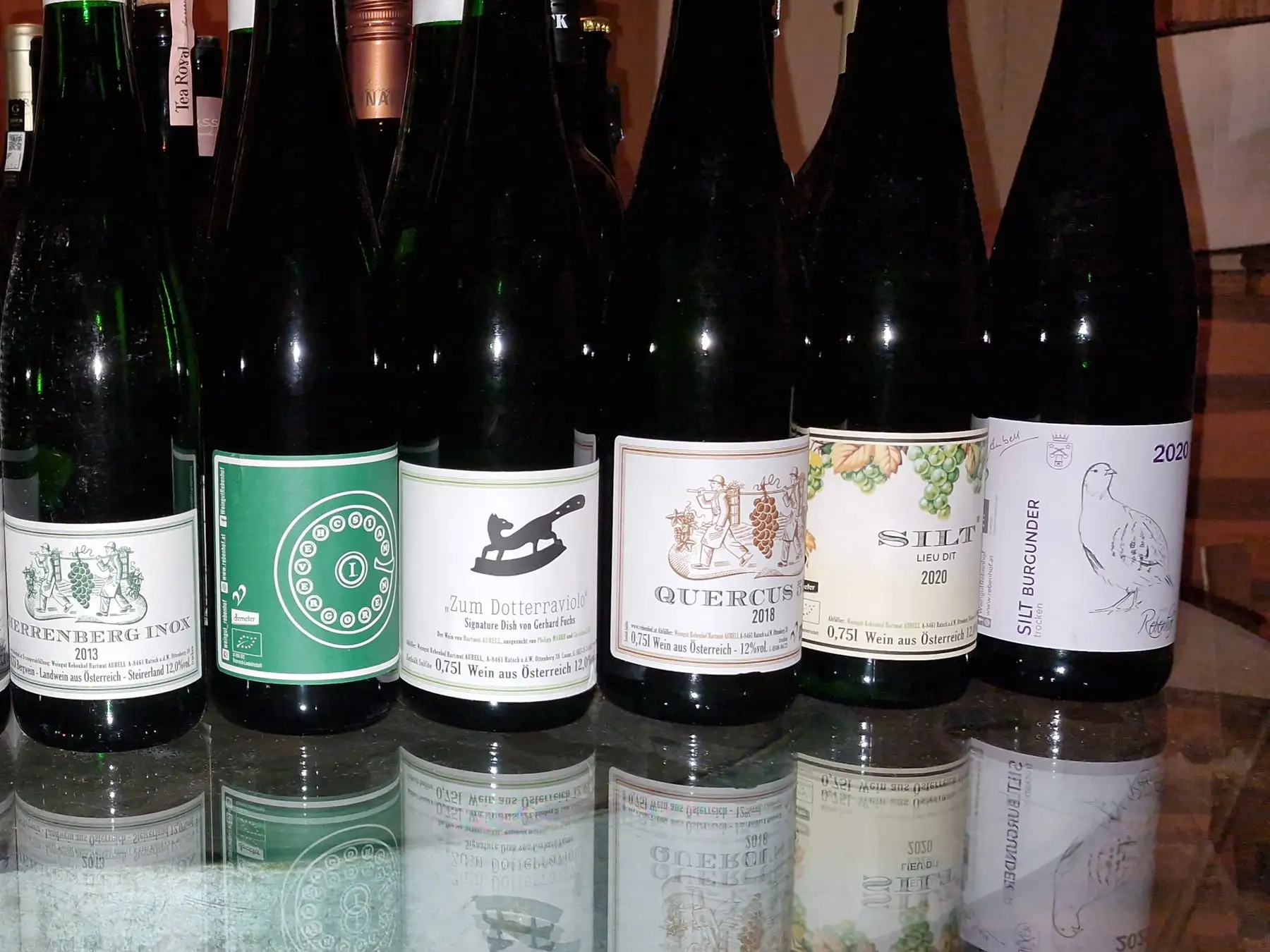 Weine vom Weingut Rebenhof aus der Südsteiermark, aufgereiht auf einem Glastisch